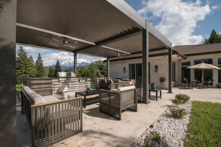 Modern backyard patio with motorized louvered pergola, outdoor kitchen, lounge seating, and mountain view